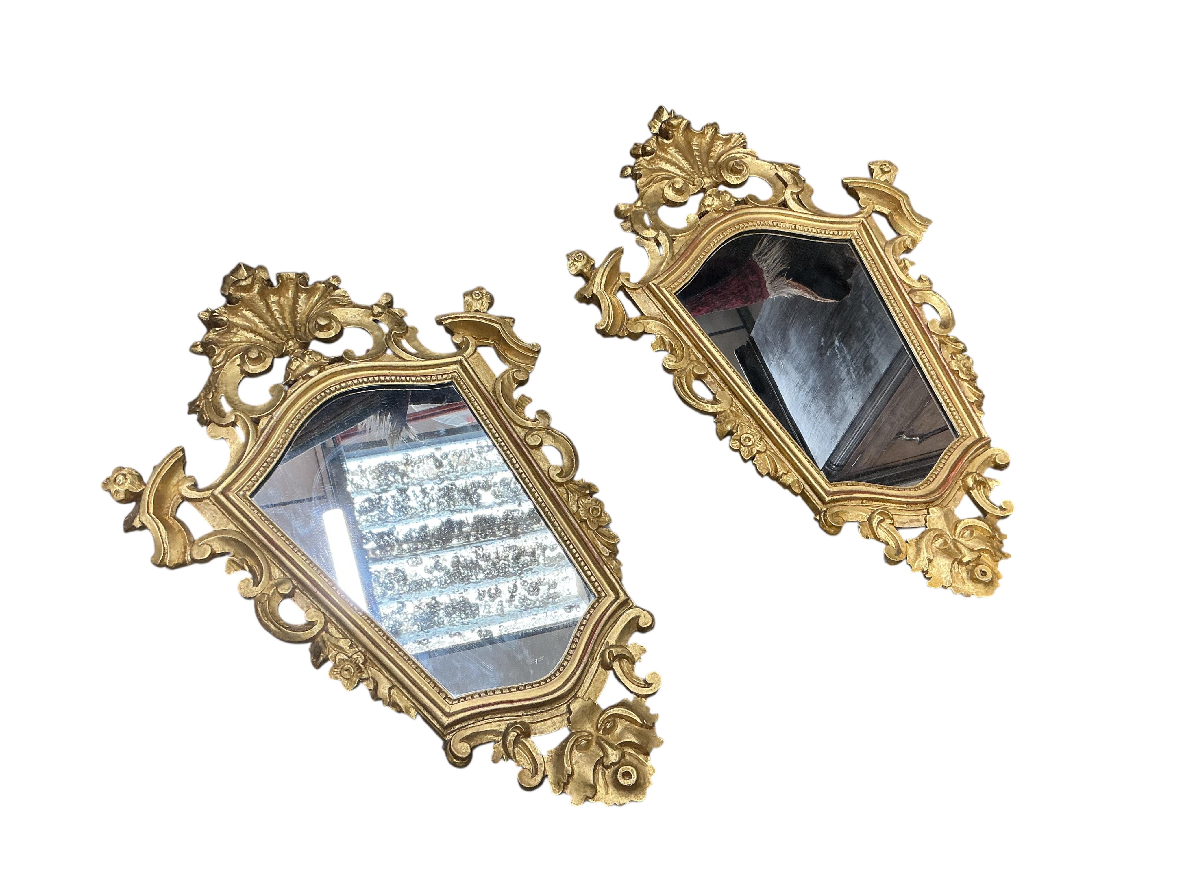 A pair of Continental carved giltwood cartouche shaped wall mirrors, width 48cm, height 77cm